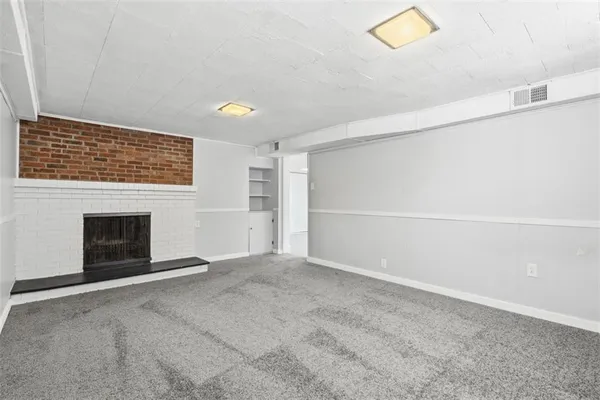 a view of an empty room with a fireplace and a window