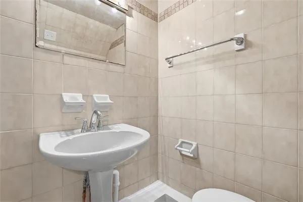 a bathroom with a sink toilet and a mirror