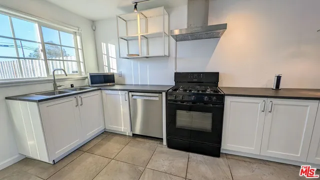 a kitchen with white cabinets and appliances