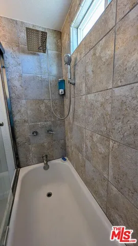 a bathroom with a white bath tub and shower