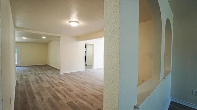 a view of a hallway with wooden floor