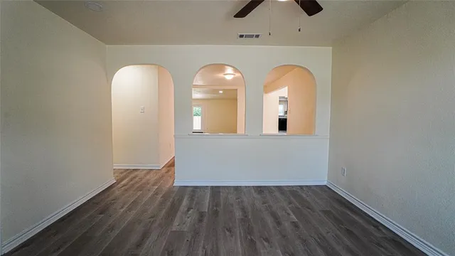 an empty room with wooden floor and mirror