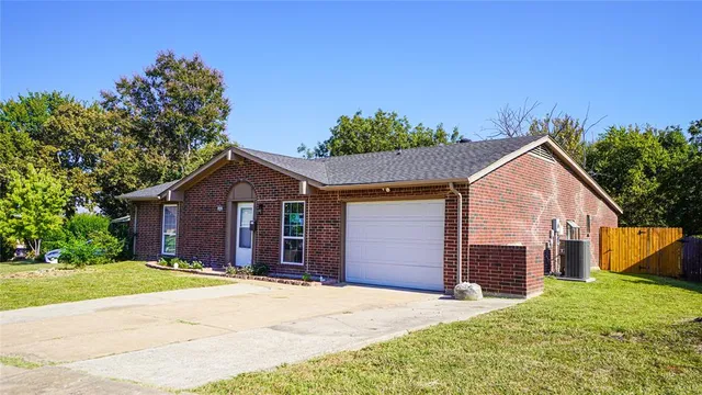 a view of a house with a yard and large tree