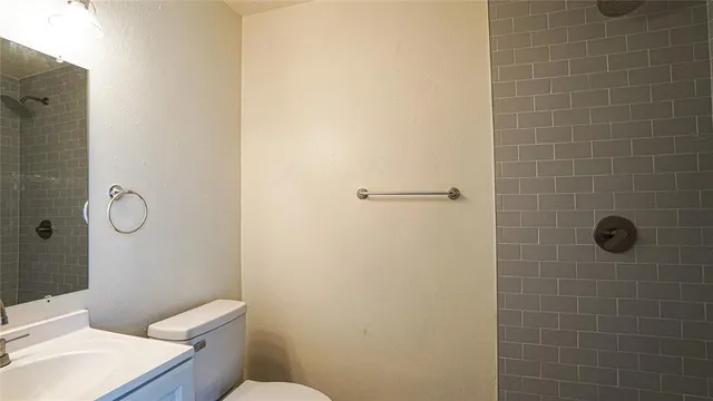 a bathroom with a toilet a sink a shower and mirror
