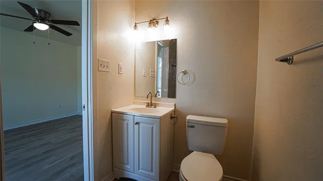 a bathroom with a toilet a sink and mirror