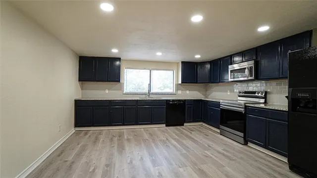 a kitchen with granite countertop wooden cabinets a stove top oven and granite counter tops