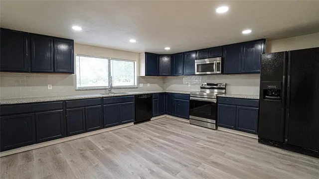 a kitchen with granite countertop stainless steel appliances and cabinets