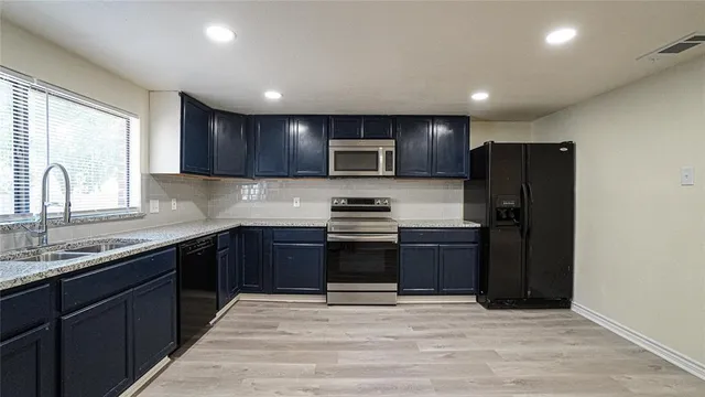 a kitchen with granite countertop stainless steel appliances and wooden cabinets