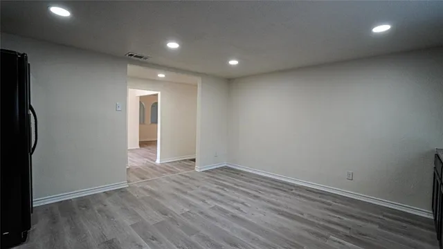 an empty room with wooden floor and a window