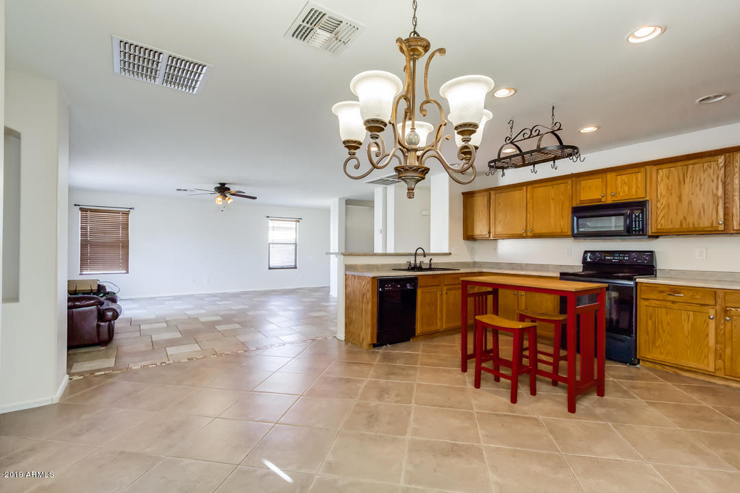 1986 West Tanner Ranch Road Queen Creek, AZ 85144 - Photo 12 of 32 a kitchen with stainless steel appliances granite countertop a sink a stove top oven and cabinets
