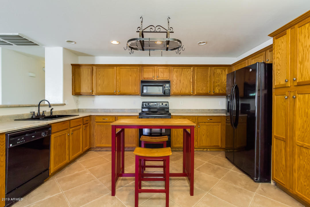 1986 West Tanner Ranch Road Queen Creek, AZ 85144 - Photo 14 of 32 a kitchen with stainless steel appliances granite countertop a sink and a refrigerator
