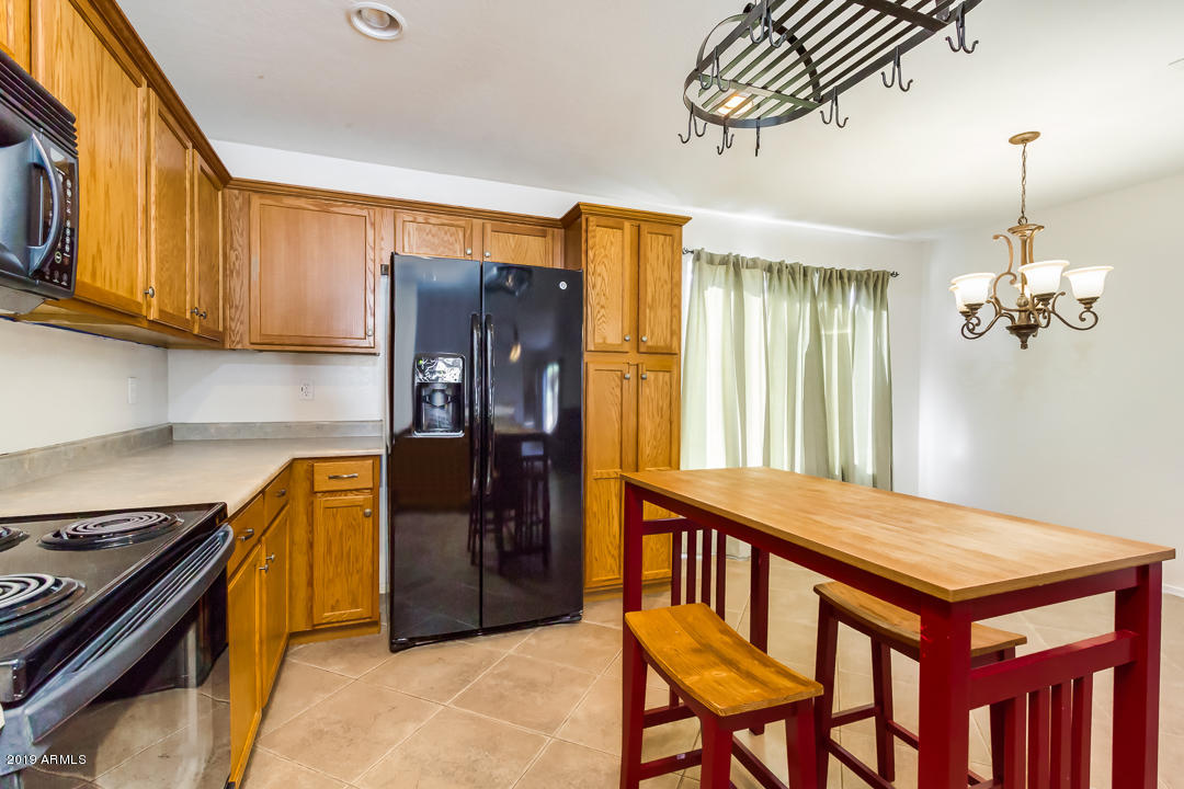 1986 West Tanner Ranch Road Queen Creek, AZ 85144 - Photo 17 of 32 a kitchen with stainless steel appliances granite countertop a stove a refrigerator and a dining table