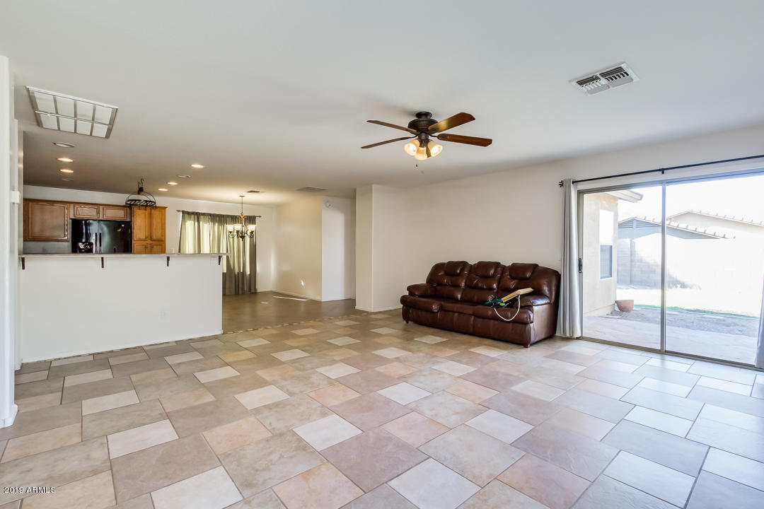 1986 West Tanner Ranch Road Queen Creek, AZ 85144 - Photo 6 of 32 a living room with furniture a ceiling fan and a rug