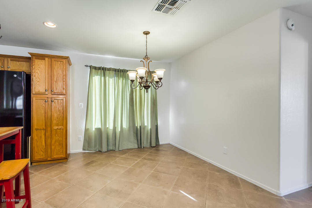 1986 West Tanner Ranch Road Queen Creek, AZ 85144 - Photo 10 of 32 an empty room with chandelier fan and windows