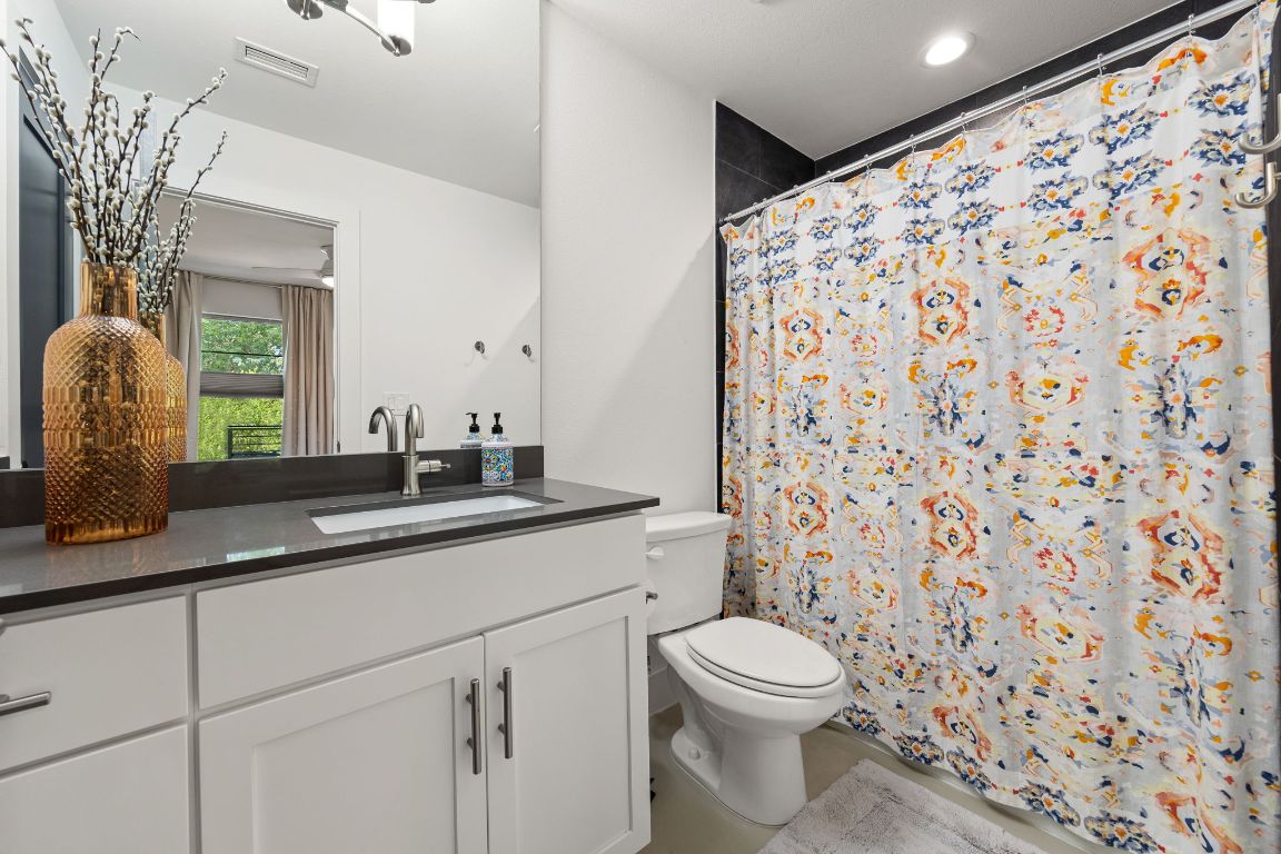 3700 Clawson Road, Unit 503 Austin, TX 78704 - Photo 16 of 39 a bathroom with a granite countertop sink a toilet and a mirror