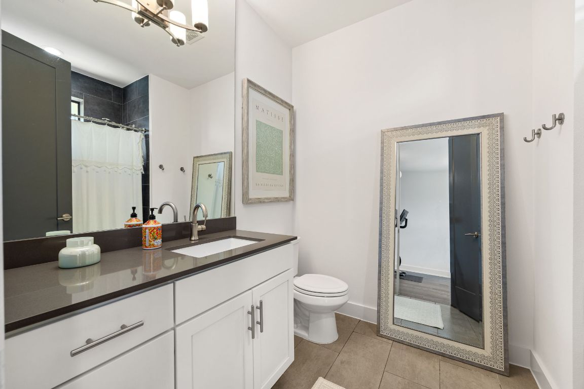 3700 Clawson Road, Unit 503 Austin, TX 78704 - Photo 24 of 39 a bathroom with a granite countertop sink a toilet and a mirror