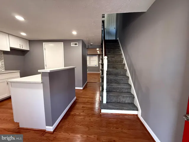 a kitchen with cabinets and wooden floor