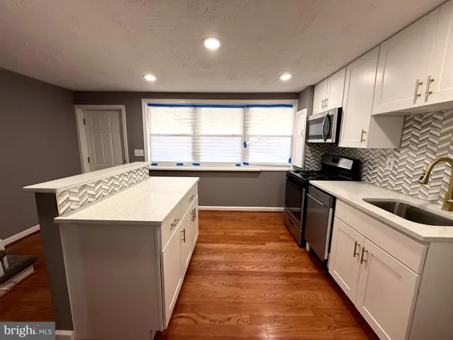 a kitchen with stainless steel appliances a refrigerator sink and wooden cabinets