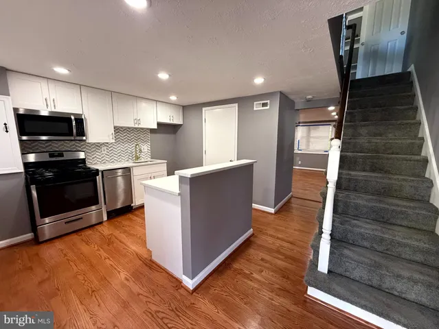 a kitchen with cabinets and wooden floor