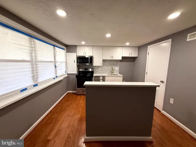 a kitchen with stainless steel appliances a refrigerator sink and wooden cabinets