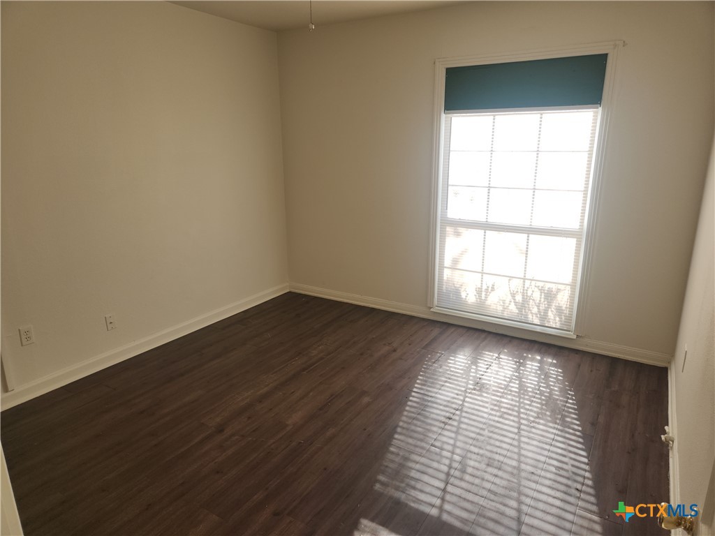 902 South 23rd Street Temple, TX 76504 - Photo 5 of 8 wooden floor in an empty room with a window