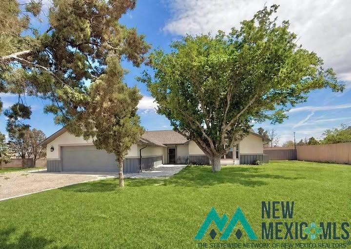 5404 Sioux Road Carlsbad, NM 88220 - Photo 6 of 100 Ranch-style residence featuring a two-car garage, expansive front lawn, and mature trees providing natural shade
