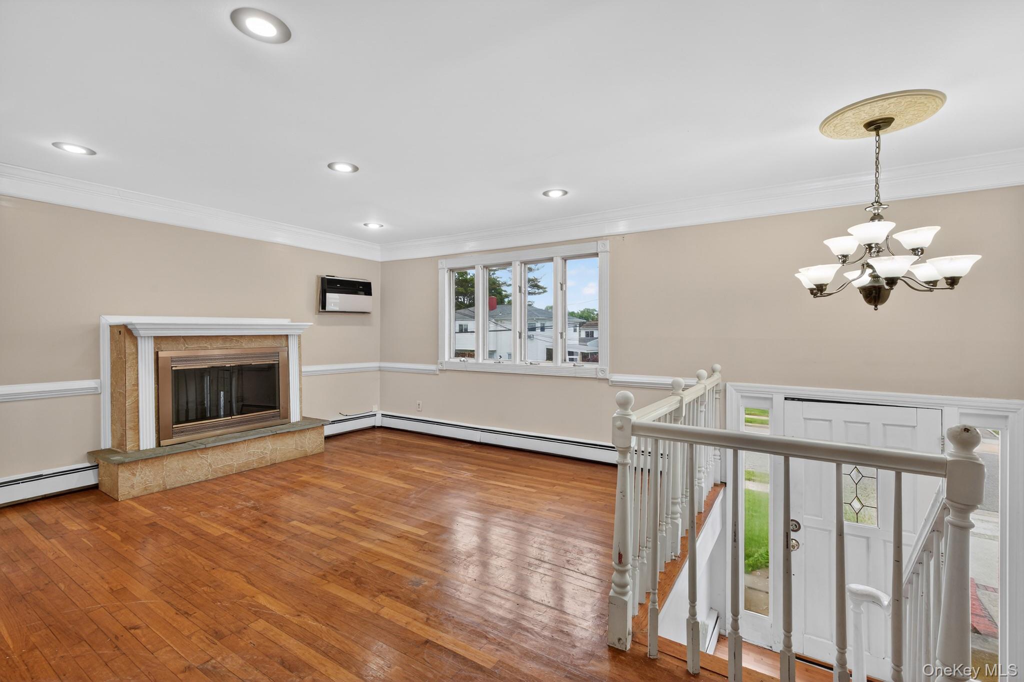 138 Spring Street Massapequa, NY 11758 - Photo 6 of 45 a view of livingroom with fireplace chandelier fan and windows