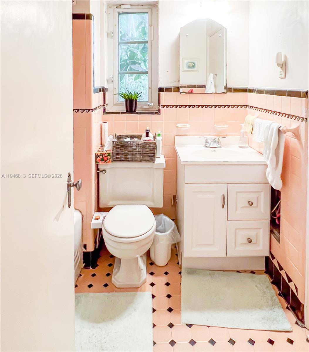 3835 Utopia Court Miami, FL 33133 - Photo 22 of 38 a bathroom with a sink a toilet and a mirror