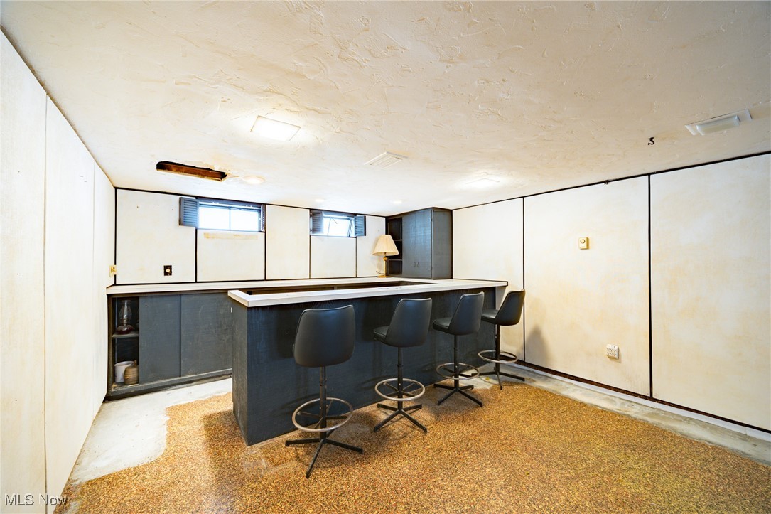 920 Clinton Avenue Cleveland, OH 44121 - Photo 12 of 14 Bar featuring white cabinetry and a textured ceiling