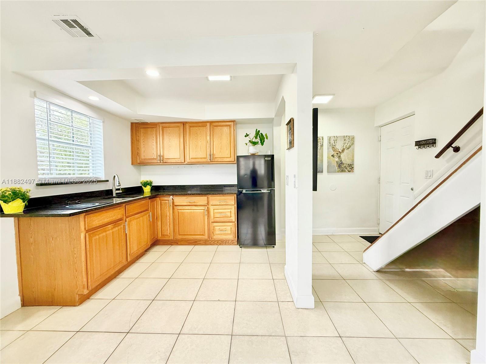 a large kitchen with stainless steel appliances granite countertop a refrigerator and a sink