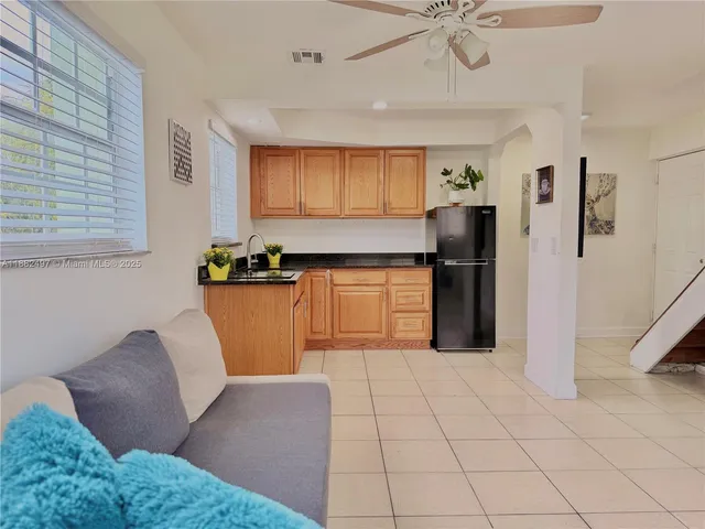 a kitchen with stainless steel appliances granite countertop a refrigerator a sink a stove top oven a counter space and cabinets