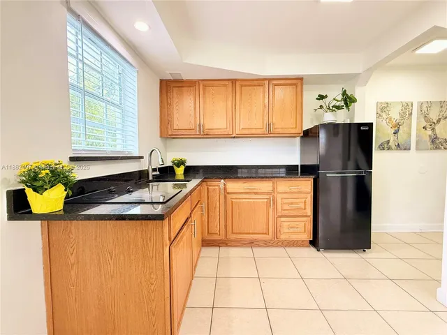 a kitchen with a sink a refrigerator and a cabinets