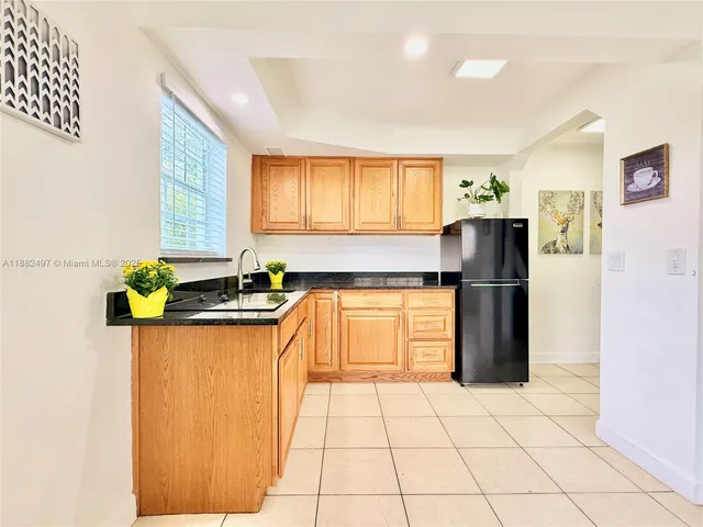 a kitchen with a refrigerator a stove top oven a sink and a window