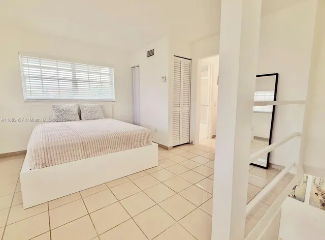 a bedroom with a bed and a large window