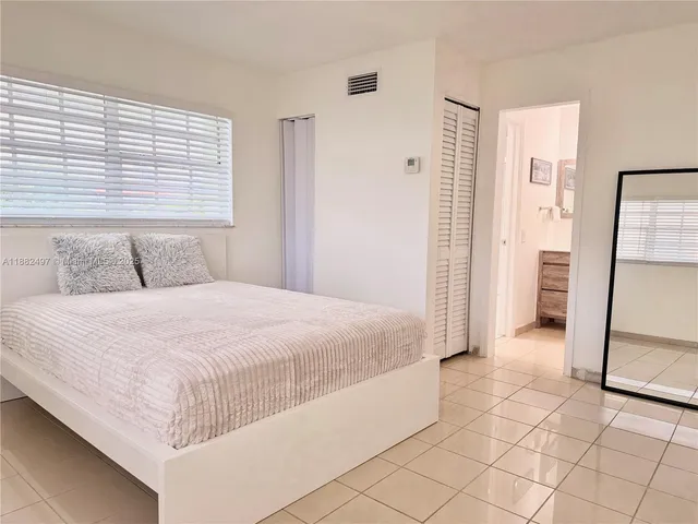 a bedroom with a bed and a large mirror