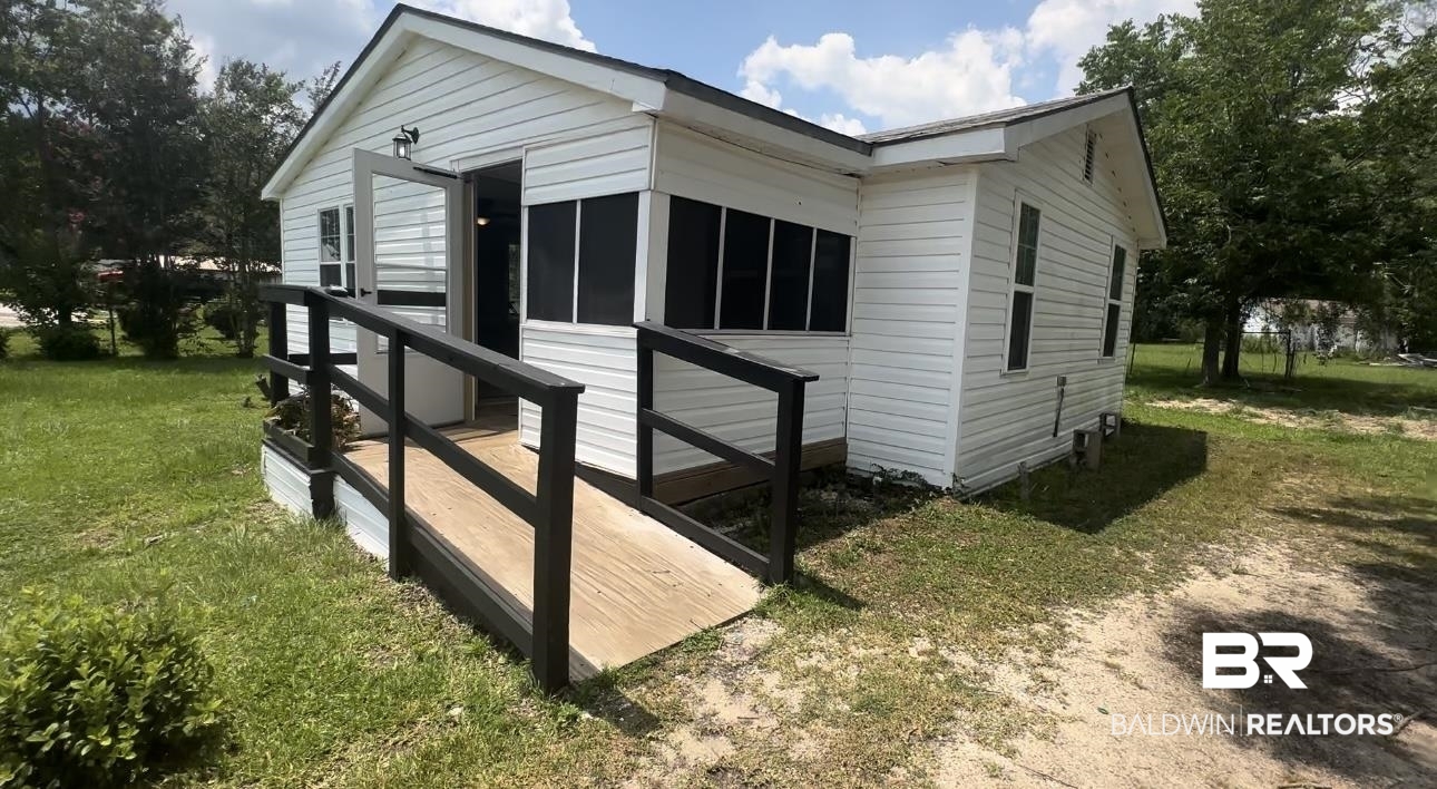 1600 Woods Road Atmore, AL 36502 - Photo 2 of 20 Exterior Entry featuring a ramp to screen porch & lawn