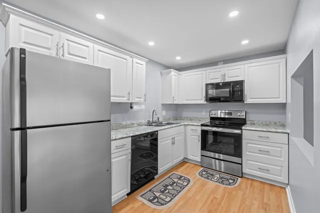 a kitchen with granite countertop a refrigerator stove and microwave