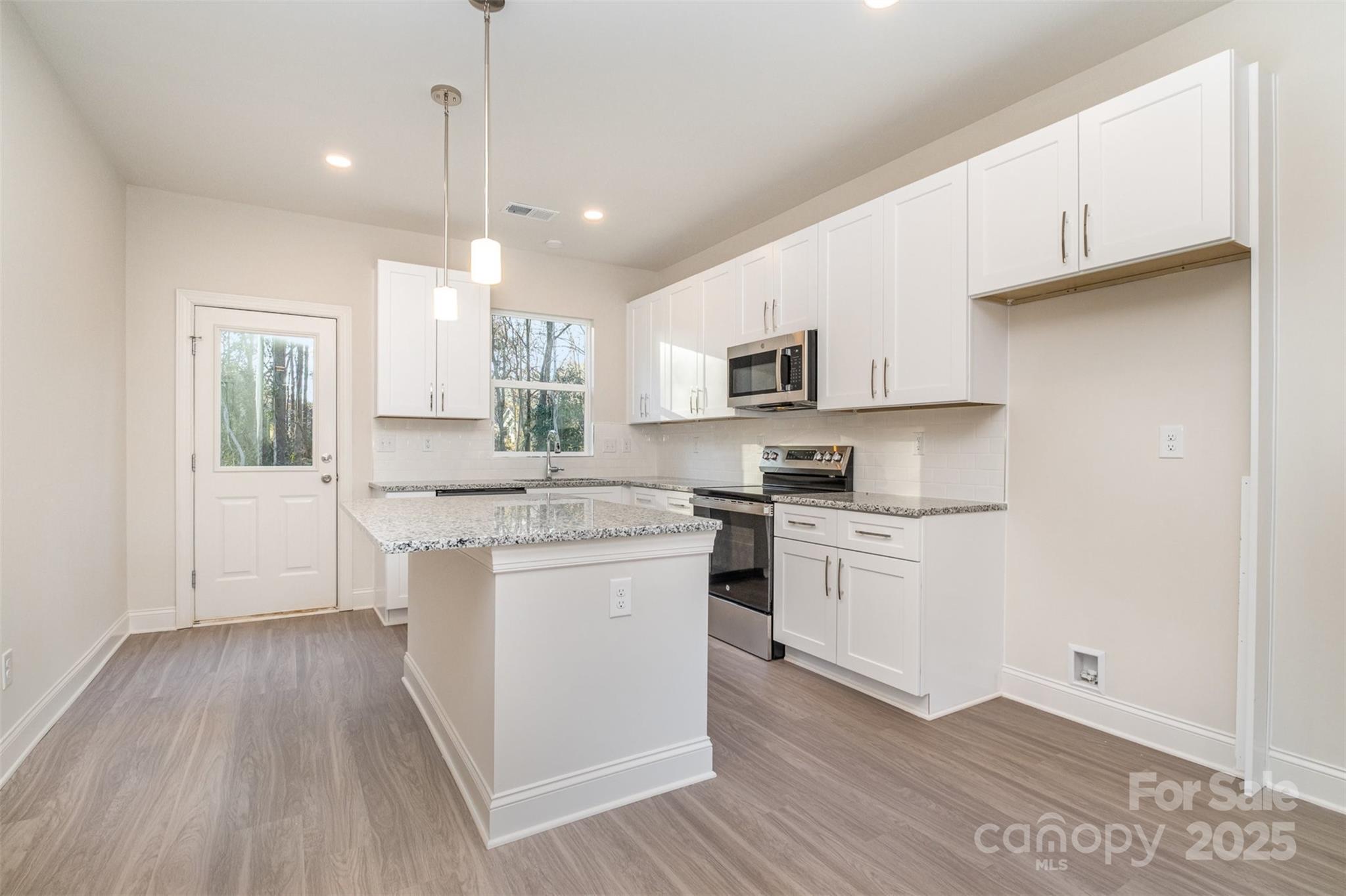 203 William Street York, SC 29745 - Photo 5 of 17 a kitchen with a white cabinets and wooden floor