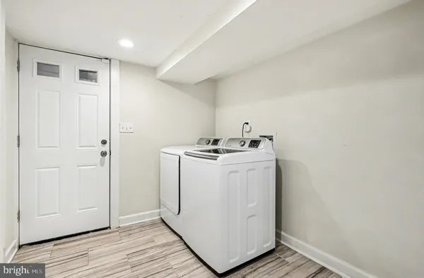 a utility room with wooden floor washer and dryer