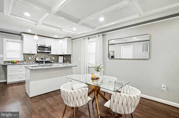 a kitchen with granite countertop white cabinets and stainless steel appliances