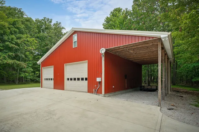 a view of a house with a lush green forest