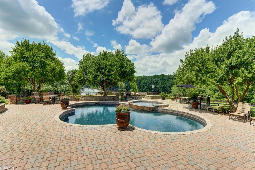 6310 Hunt Road Pleasant Garden, NC 27313 - Photo 2 of 30 Vacation everyday! Rejuvenate in the free form heated concrete pool with paver surround and splash over hot tub for at least 6 friends/or family! Recently resurfaced, from 3 feet to 5 feet in depth. Plenty of space for the party!