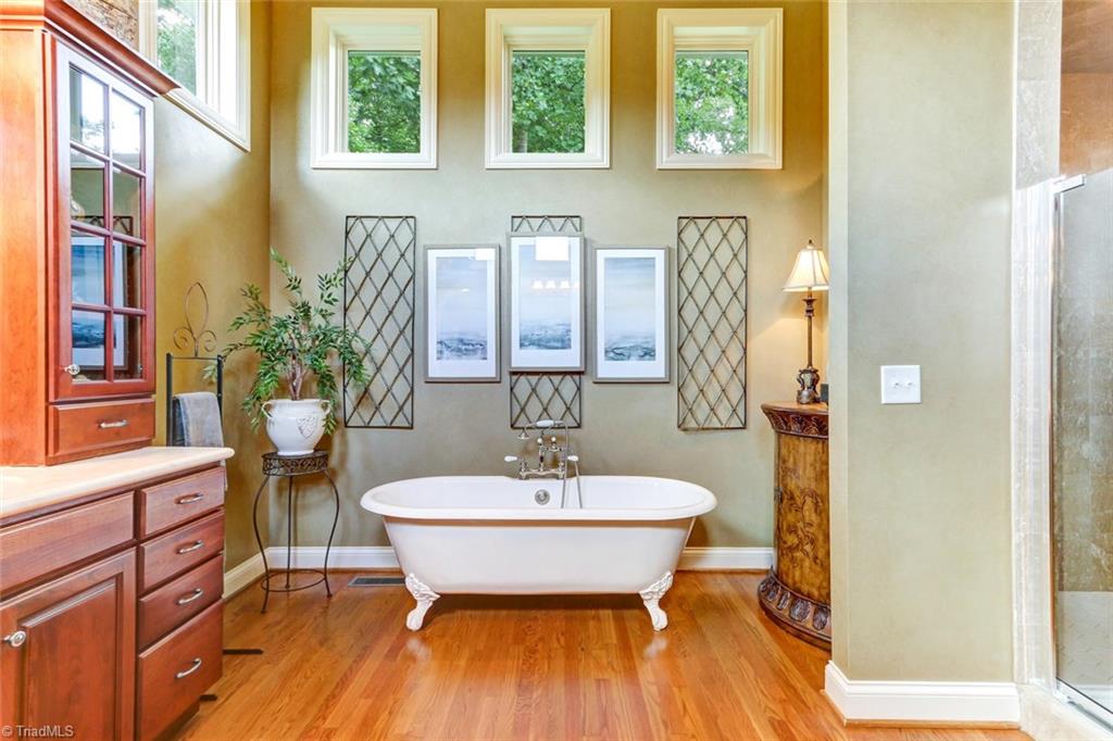 6310 Hunt Road Pleasant Garden, NC 27313 - Photo 18 of 30 Soak in luxury in the claw footed free standing tub or enjoy the 2 headed separate shower in a calming setting.. Abundant custom cabinetry flank two walls with double sinks and dressing area. Texas size master closet adjoins the dressing area.