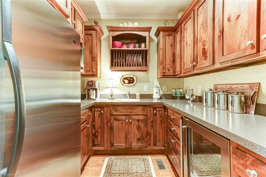 6310 Hunt Road Pleasant Garden, NC 27313 - Photo 10 of 30 The pantry that beats all pantries! Or is it a butler's kitchen? Strategically located near the rear door with pool access, this pantry/kitchenette is the perfect place to grab and go. Beverage cooler, 2nd refrigerator, microwave, and cabinets galore.