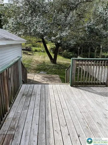 a white house that has tree in front of a house