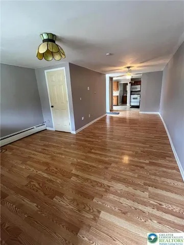 a view of empty room with wooden floor and window