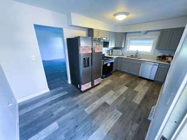 a kitchen with stainless steel appliances wooden floors and wooden cabinets