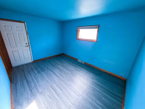 a view of a room with wooden floors and window