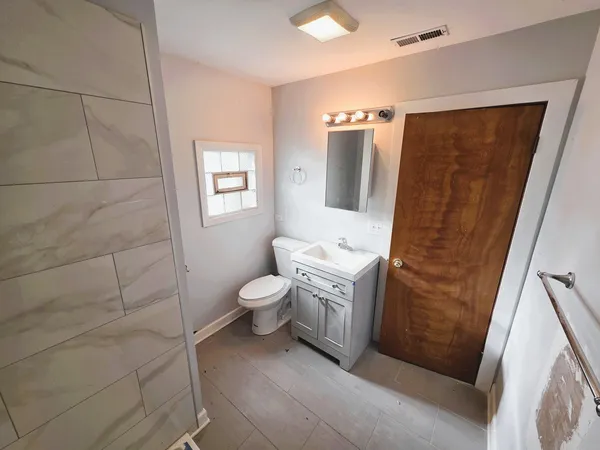 a bathroom with a granite countertop sink toilet and shower