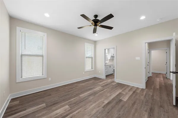 a view of a big room with wooden floor and windows